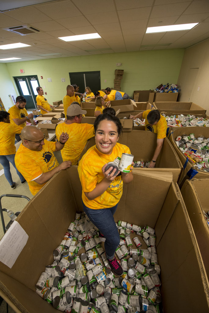 Sandra Carrillo, a communications intern at Chesapeake Utilities Corporation’s corporate office, gets to the bottom of a very large box of donated canned goods as her father Sergio Carrillo, Director of Corporate Development, smiles and adds an extra hand.
